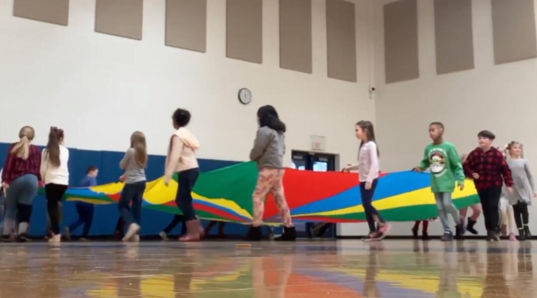 Students in the gym using the parachute
