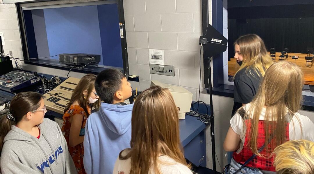 Students exploring the sound and light booth of the theater.